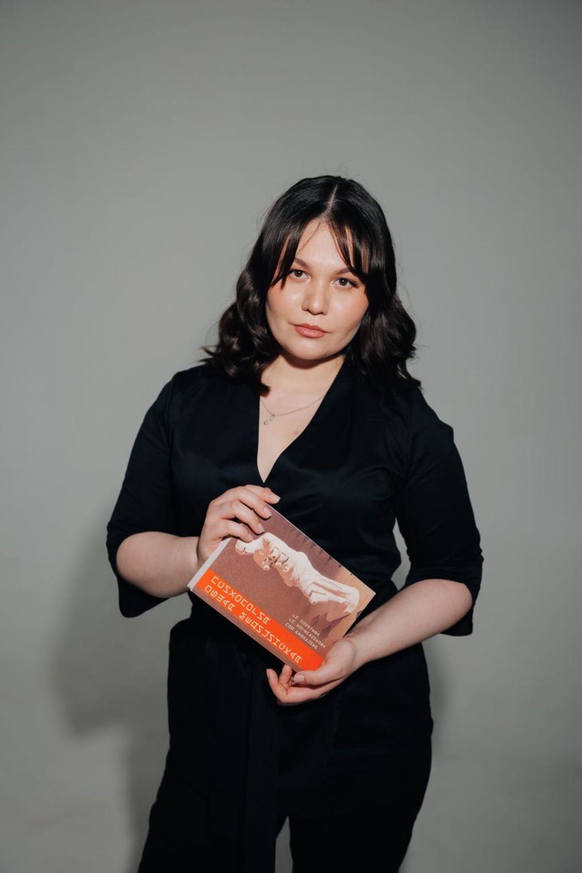 A proud author holding their newly published book